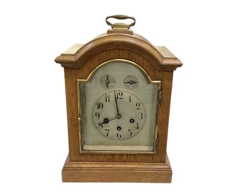 An early 20th century oak cased mantel clock with silvered dial, height 36cm, width 27cm.