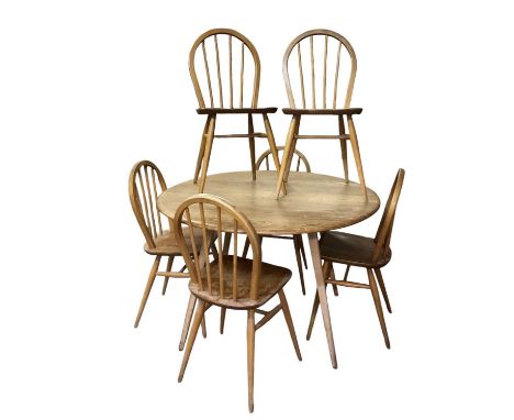 ERCOL; a mid century elm drop-leaf circular dining table, diameter when extended 125cm, with set of six spindle back dining c
