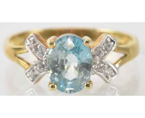 A 9ct yellow gold zircon set ring, the central oval cut blue zircon approx 2.7ct, flanked by four small white zircon, combine