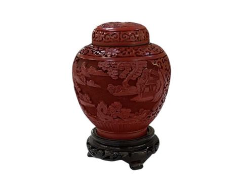 A modern Chinese cinnabar lacquer ginger jar, on carved hardwood base, height 19cm.