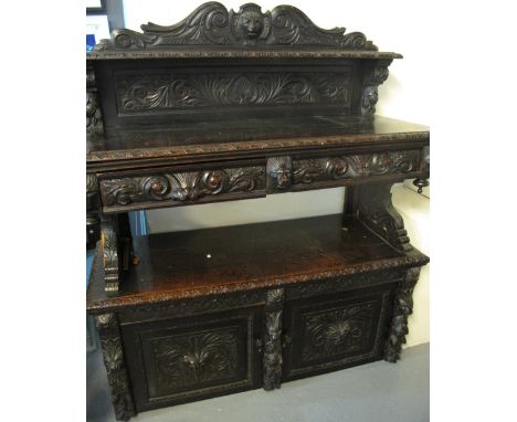 Victorian stained oak carved Flemish design buffet with mask mounts and deeply carved panels, two drawers, two blind panelled