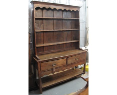 18th Century style oak potboard dresser with boarded three shelf rack back over two deep drawers with shape frieze below on s