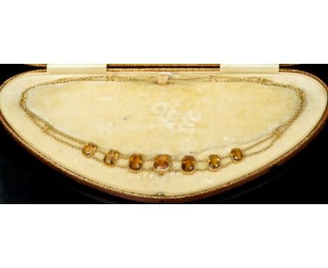 Edwardian topaz necklace with seven octagonal step cut topaz in yellow metal collet setting on a double row of chain links, w