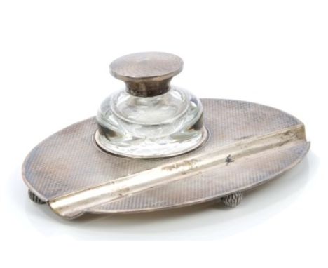 1920s silver inkstand of oval form in the Art Deco style, with engine-turned decoration and pen well, separate cut glass inkw