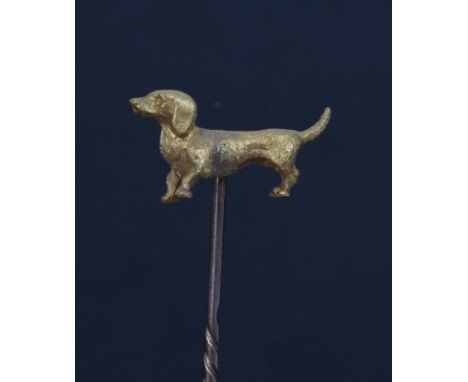 Edwardian yellow metal stick pin surmounted with a cast and chased yellow metal dachshund, stamped '15C', 20mm