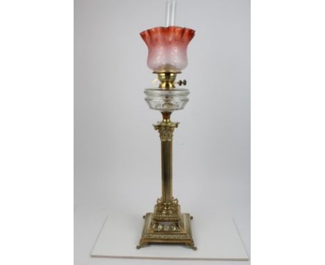 Good Victorian cast brass oil lamp, with clear funnel, red tinted shade, above a brass section with adjusters marked Duplex, 