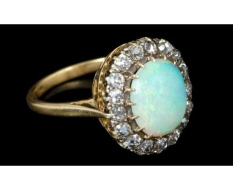 Opal and diamond cluster ring with an oval cabochon opal measuring 11mm x 9.5mm x 4mm, surrounded by seventeen old cut diamon