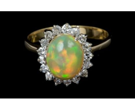 Opal and diamond cluster ring with an oval cabochon opal measuring approximately 10.4mm x 8.2mm x 4.7mm, surrounded by a bord