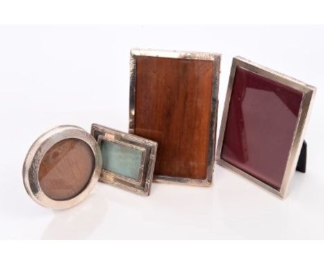 Three early 20th century silver mounted photograph frames (various dates and makers), together with a contemporary silver fra