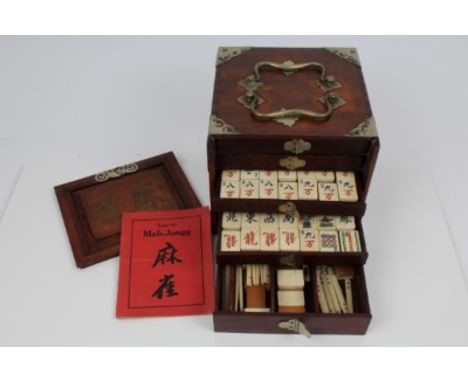 Early 20th century Chinese mahjong set in a fitted hardwood and metal mounted case, the lift-up front revealing five fitted d