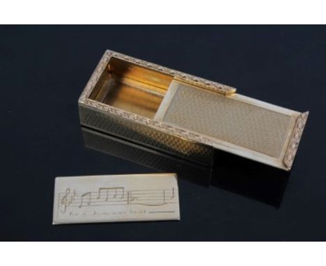 Gold (9ct) box with sliding lid and cast edge with engine-turned ground, the box containing a gold plaque with engraved music