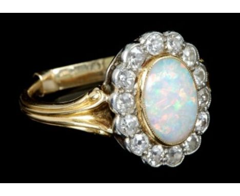 Late Victorian opal and diamond cluster ring with an oval cabochon opal measuring approximately 11.5mm x 8mm x 3.2mm, surroun