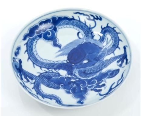 Antique Chinese blue and white saucer dish decorated with swirling dragon chasing a pearl and waves to underside, with underg