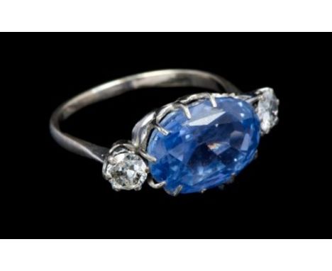 Sapphire and diamond three stone ring with an oval mixed cut cornflower blue sapphire flanked by two old cut diamonds in claw