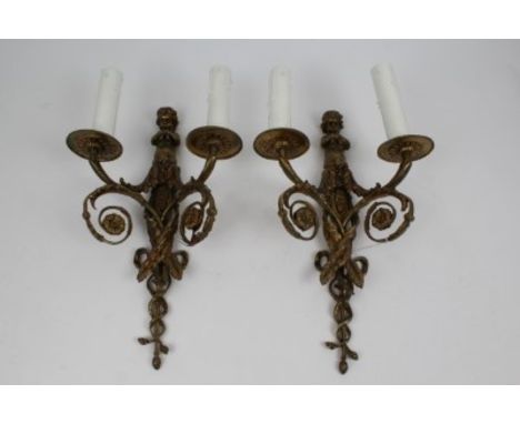 Pair of early 20th century gilt brass two-branch wall lights, the back with cast figure of Pan playing the pipes, gilt leaf s