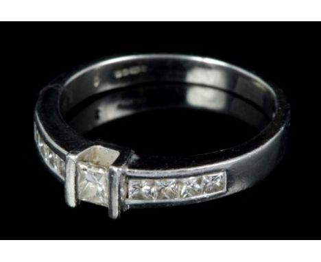 Platinum and diamond ring with a principal princess cut diamond weighing approximately 0.20 carats, flanked by eight further 