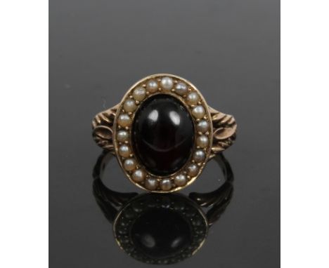 Georgian garnet and seed pearl oval cluster ring with an oval cabochon garnet surrounded by a border of seed pearls with acan