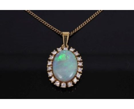 Opal and diamond cluster pendant with an oval cabochon opal measuring approximately 17.7mm x 13.0mm x 5.2mm, surrounded by a 