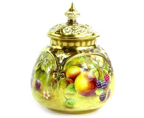 A Royal Worcester porcelain vase and cover, the lid with pierced decoration, the base decorated with fruit by B Cox, with gil