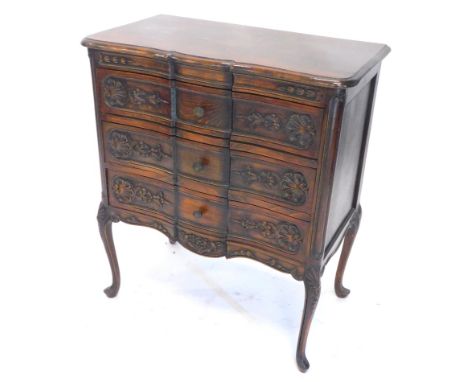 A continental stained beech serpentine commode chest, the break front top with a moulded edge, above three drawers, each carv