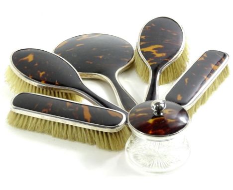 A George V silver and tortoiseshell backed dressing table set, comprising two hair brushes, 23cm W, two clothes brushes, a li