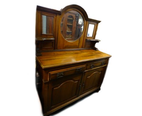 An early 20thC walnut sideboard, the raised back with a central circular bevelled mirror plate, flanked by two smaller rectan