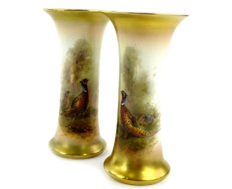 A pair of Royal Worcester porcelain vases, each decorated with pheasants in a landscape by James Stinton, printed marks in bl