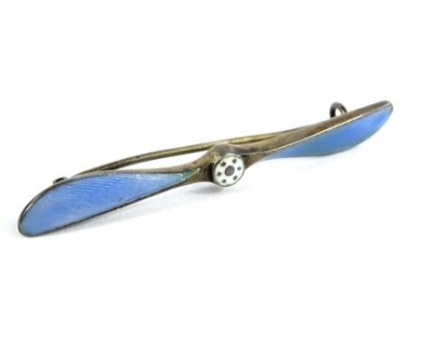 A silver and enamel aeroplane propeller brooch, the propeller set with blue enamel wings and white enamel centre, marked to r