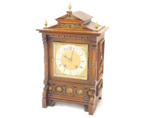 A late 19thC German mantel clock, in oak case, with brass mounts, the shaped pediment applied with later pineapple finial's a