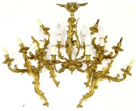 A set of four large gilt metal wall lights, each with rococo scroll casting, 56cm H and a similar six branch gilt metal chand