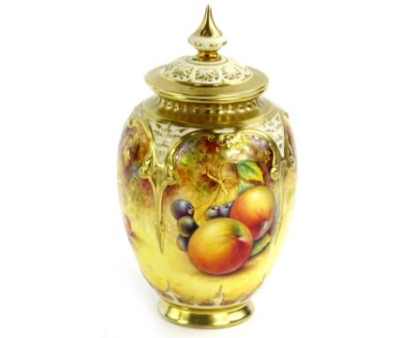 A Royal Worcester porcelain vase and cover, decorated with fruit by Paul English, the pierced lid with a tapering finial, the