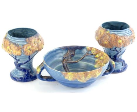 Three items of Carltonware relief moulded porcelain, to include a pair of vases each decorated with trees within ribbed blue 