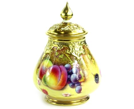 A Royal Worcester porcelain vase and cover, with a pierced lid, the base decorated with fruit by P Platt, printed mark in bla