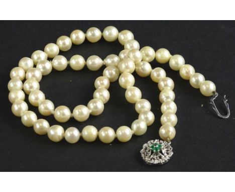 A cultured pearl necklace, with white gold clasp, marked 585, set with four emeralds, each bead 5mm wide, 47cm long plus clas
