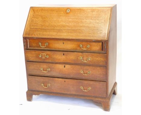 A George III oak bureau, the fall enclosing a fitted interior, above four graduated drawers with brass drop handles and brack