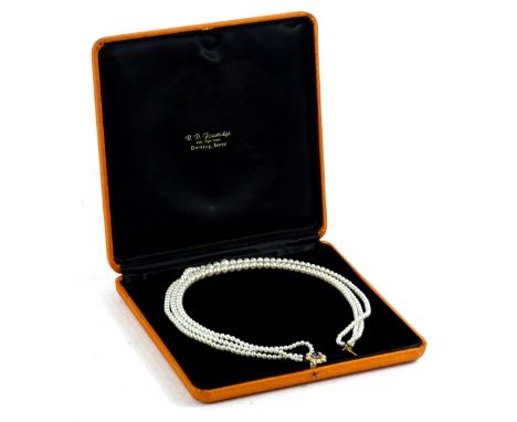 A 9ct gold and three row cultured pearl necklace, the clasp in floral design with oval cut amethyst and set with eight seed p