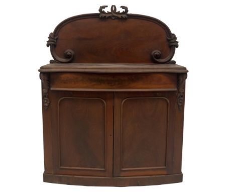 A Victorian mahogany chiffonier, with scroll carved and flamed back, serpentine moulded top, bowfront frieze drawer over two 