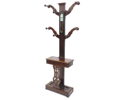 A Victorian mahogany coat or hall stand, with central mirror and shaped arms with turned hooks or pegs, the base with a hinge