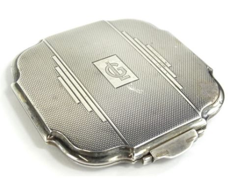 An Edward VIII Art Deco silver powder compact, the hinged lid enclosing a mirror and a brass compartment for powder, Birmingh