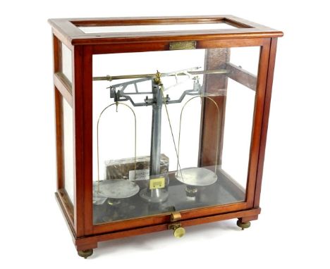 An Oertling set of laboratory scales, in aluminium and brass, in a glazed mahogany case, 49cm H, 45cm W.