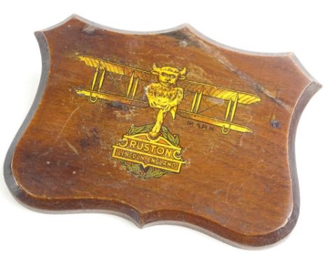 An early 20thC mahogany plaque, decorated with a transfer print of a gilt bi plane and the crest of the Ruston factory of Lin