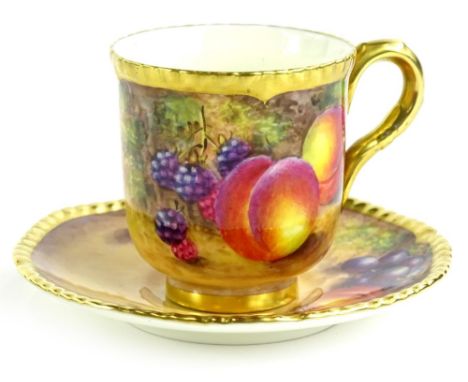 A Royal Worcester porcelain cup and saucer, decorated with fruit by Freeman, printed mark in black to underside, in presentat