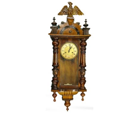 A late 19th/early 20thC walnut Vienna type wall clock, with a composite gilt eagle to the shaped crest, above part fluted and