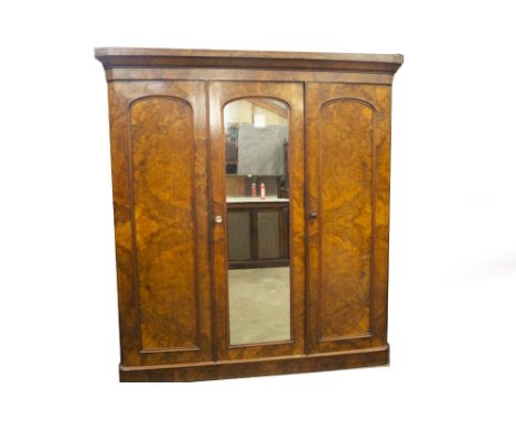 A Victorian burr and figured walnut triple wardrobe, with moulded cornice, arch moulded mirror centre door, revealing a doubl