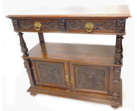 A late Victorian carved oak buffet, the top with a moulded edge above two frieze drawers on turned supports, the base with tw