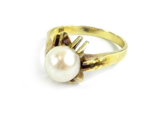 A culture pearl dress ring, with sunburst type design, forming four points and two extra points as shoulders, on yellow metal