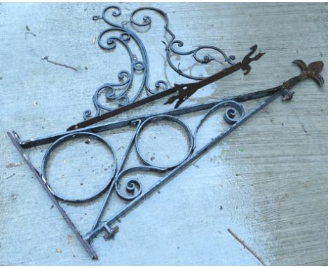 A wrought iron bracket for a hanging basket or a large sign, and a similar smaller example, the largest 129cm L.