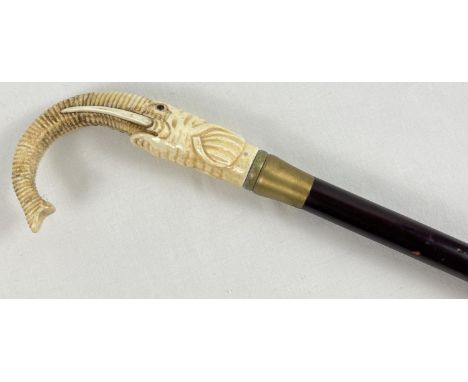 A bone topped walking cane with screw in finial in the form of an elephant head with curved trunk hand grip. Approx. 90cm lon