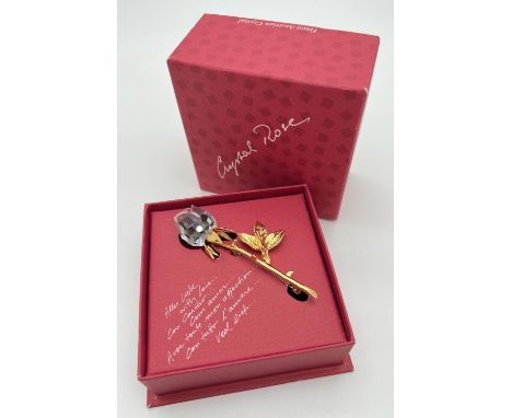 A boxed Art 9446 930 001 Crystal Rose brooch by D. Swarovski &amp; Co. Gold tone stem and leaves with faceted crystal rose. A