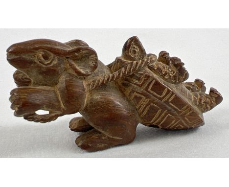 A carved wooden netsuke modelled as a mouse pulling a tortoise. Set with small mother of pearl disc to underside and with tog